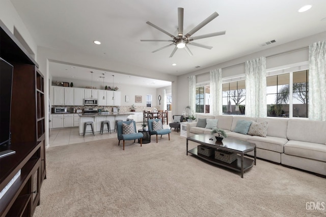 carpeted living room featuring ceiling fan