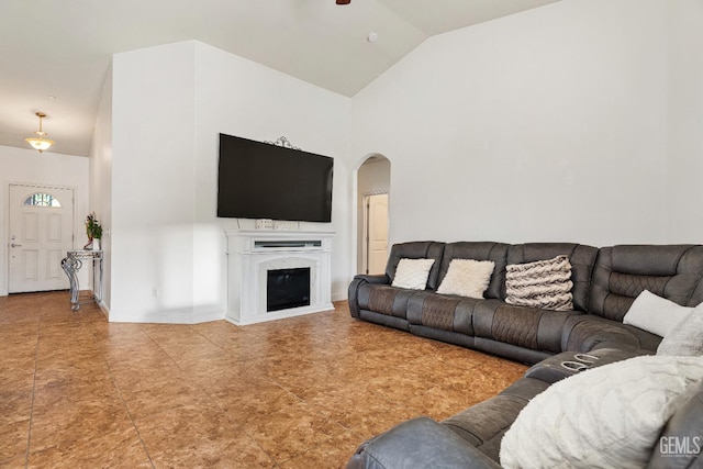 605 Cornelia St, Wasco, CA 93280 - living room with arched walkways, a glass covered fireplace, a ceiling fan, and high vaulted ceiling