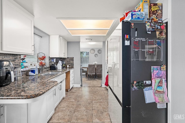5104 Silver Crossing St, Bakersfield, CA 93313 - kitchen featuring freestanding refrigerator, a sink, tasteful backsplash, white cabinets, and dark stone countertops