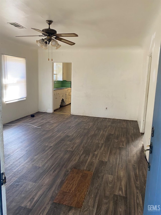 unfurnished room featuring dark wood-type flooring and ceiling fan