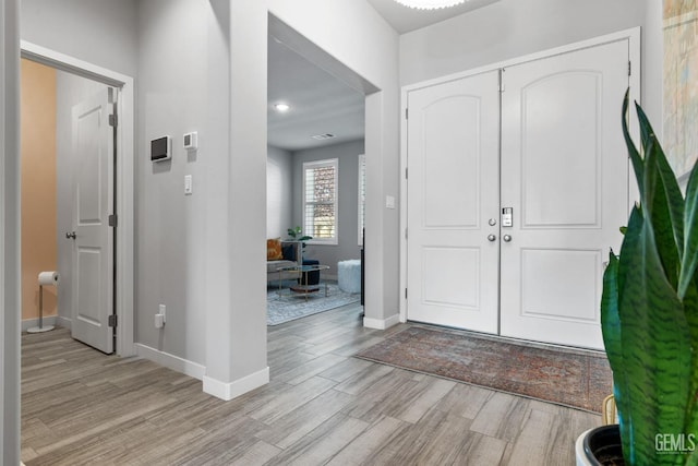 foyer with light wood-style floors and baseboards