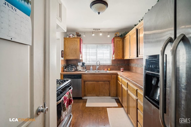 2209 Barnett St, Bakersfield, CA 93308 - kitchen with appliances with stainless steel finishes, wood finished floors, light countertops, and brown cabinetry