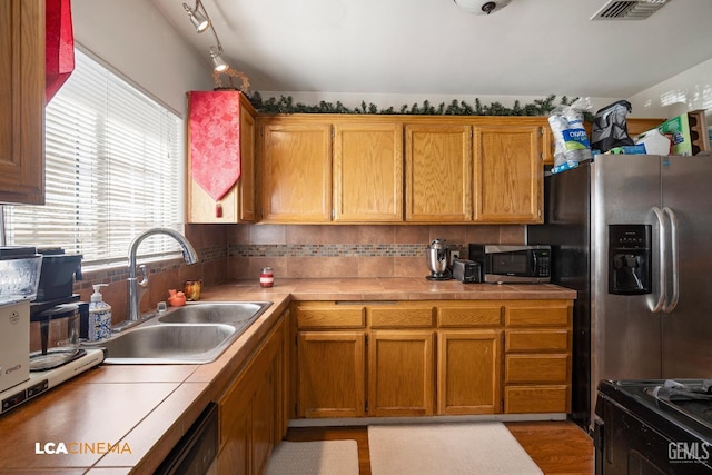 2209 Barnett St, Bakersfield, CA 93308 - kitchen featuring appliances with stainless steel finishes, brown cabinetry, and tile counters