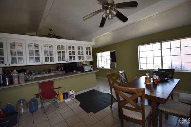 kitchen featuring vaulted ceiling with beams, ceiling fan, white cabinetry, and light tile patterned floors