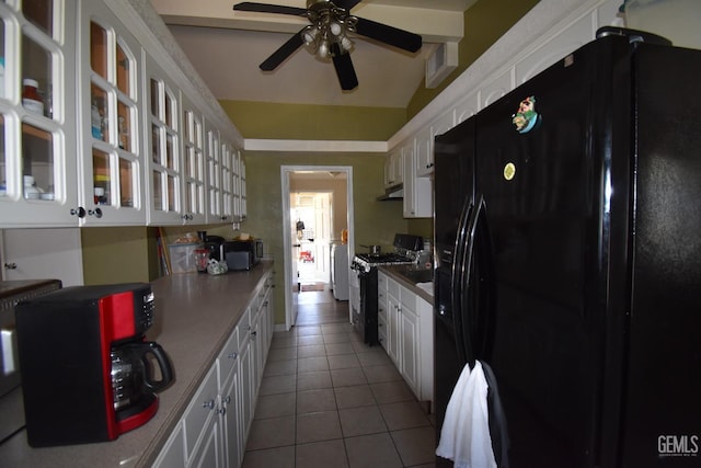 kitchen with white cabinetry, black refrigerator with ice dispenser, lofted ceiling, and range with gas stovetop