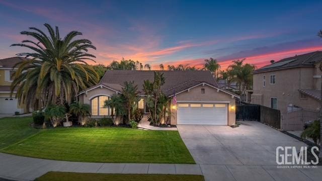 view of front of property with a garage and a lawn