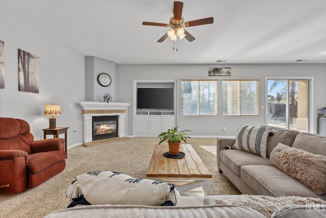 carpeted living room with ceiling fan