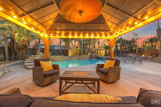 pool at dusk featuring a patio, a gazebo, and pool water feature