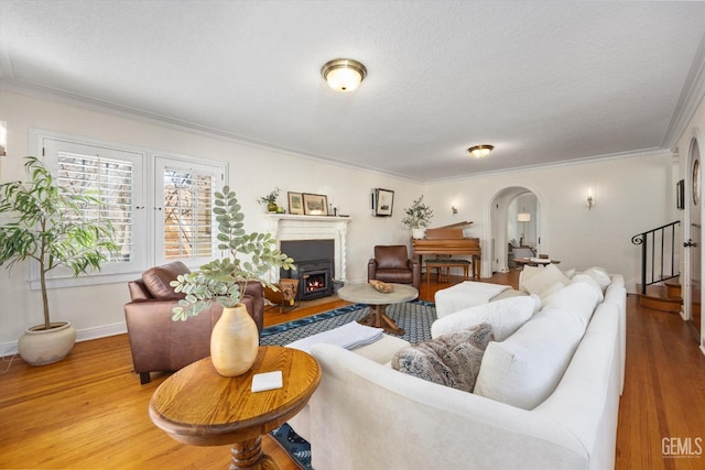 living room featuring arched walkways, a textured ceiling, and wood finished floors