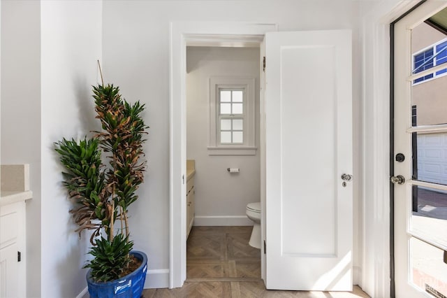 bathroom featuring vanity, toilet, and baseboards