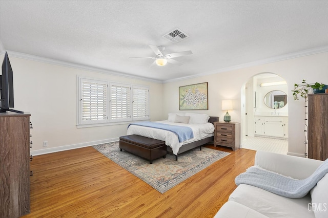 bedroom featuring visible vents, ornamental molding, baseboards, and wood finished floors