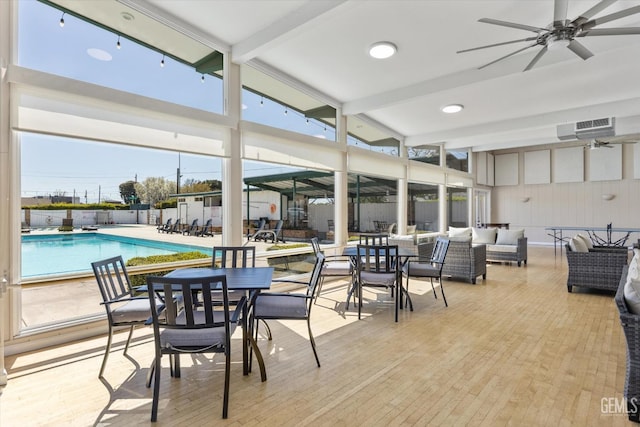 interior space featuring beamed ceiling, plenty of natural light, and a ceiling fan