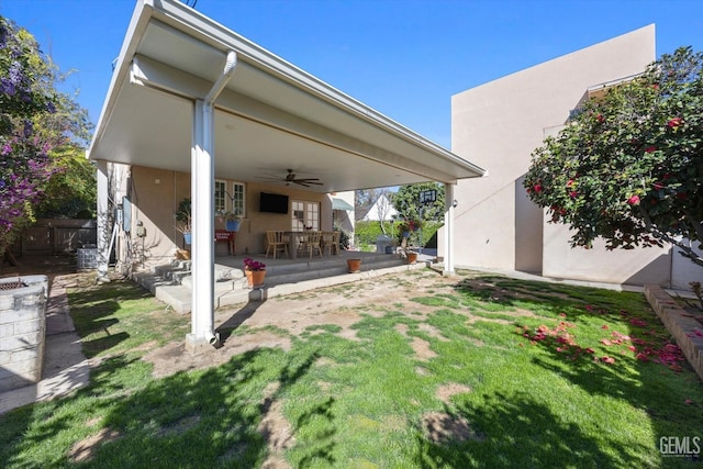 view of yard with ceiling fan and a patio area