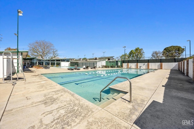 pool with a patio and fence