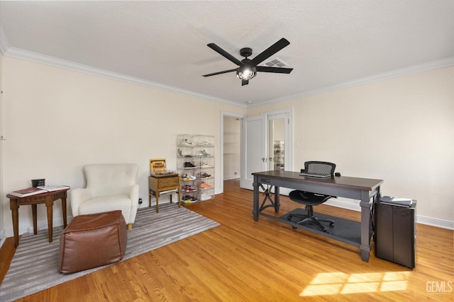 home office featuring ceiling fan, ornamental molding, and light wood finished floors