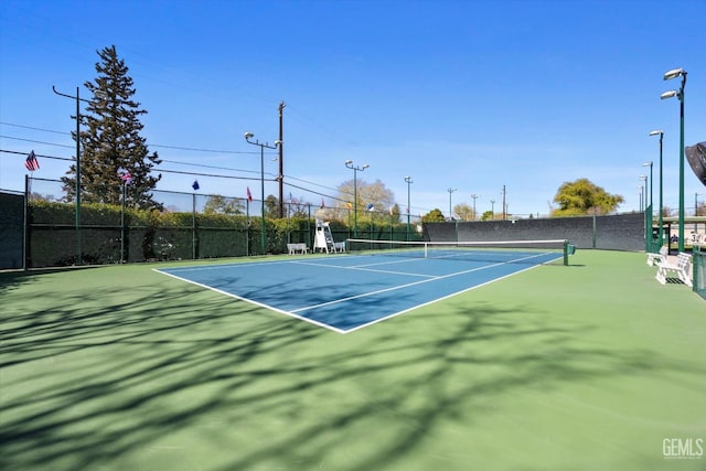 view of tennis court featuring fence