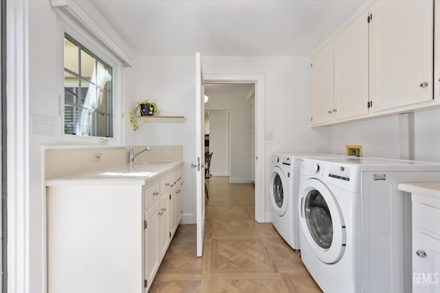 laundry area with washer and dryer, cabinet space, and a sink