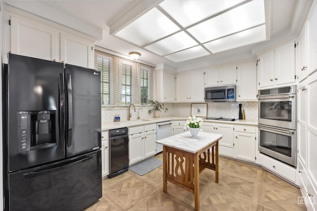 kitchen with white cabinetry, black appliances, light countertops, and a sink