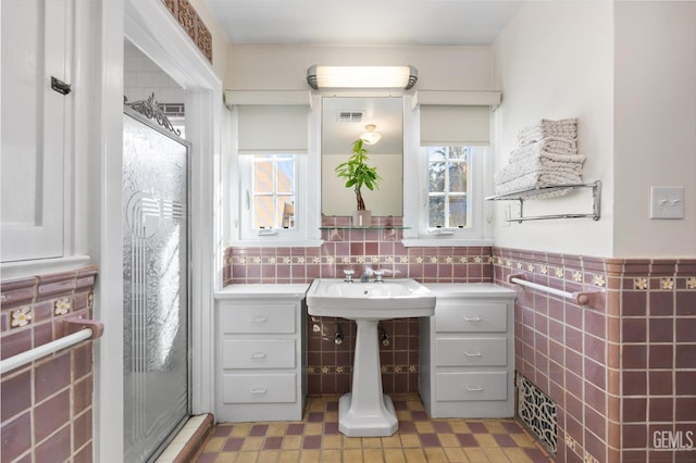 full bath featuring wainscoting, visible vents, a healthy amount of sunlight, and tile walls