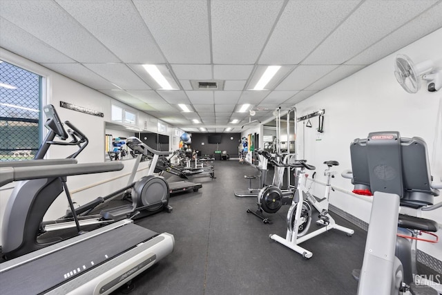 workout area with a drop ceiling, baseboards, and visible vents