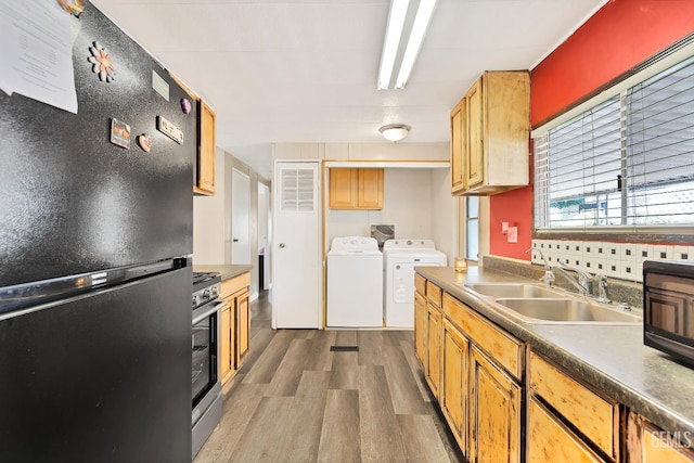 3601 S Chester Ave Unit 12, Bakersfield, CA 93304 - kitchen featuring black appliances, washing machine and clothes dryer, wood finished floors, and dark countertops