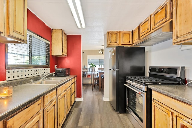 3601 S Chester Ave Unit 12, Bakersfield, CA 93304 - kitchen featuring stainless steel gas range oven, dark wood-type flooring, dark countertops, under cabinet range hood, and freestanding refrigerator