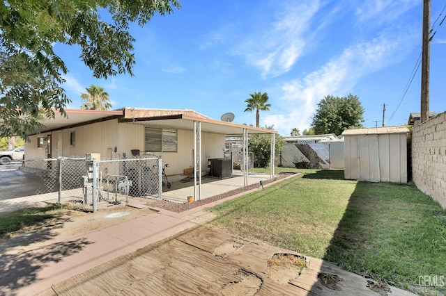 3601 S Chester Ave Unit 12, Bakersfield, CA 93304 - back of property with a fenced backyard, a storage shed, an attached carport, and a patio area