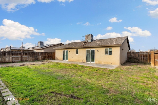 back of house with a lawn and a patio