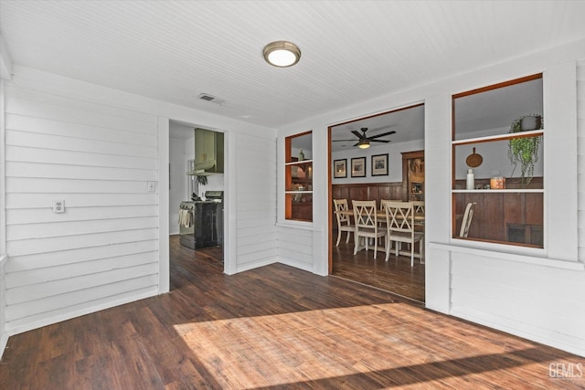 unfurnished room with dark wood-style flooring, visible vents, and a ceiling fan