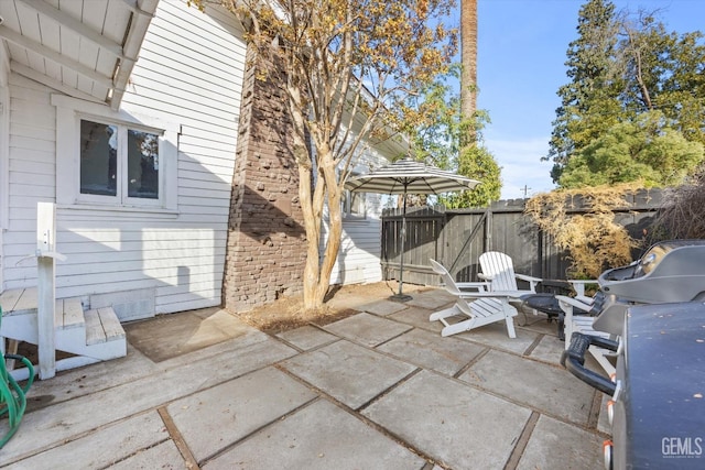 view of patio featuring area for grilling and fence