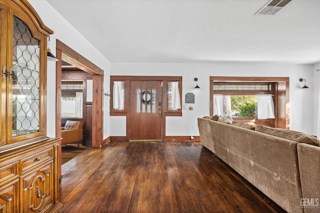 foyer entrance featuring dark wood-type flooring, visible vents, and baseboards