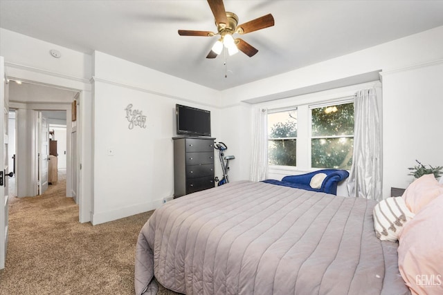 bedroom featuring a ceiling fan, light carpet, and baseboards