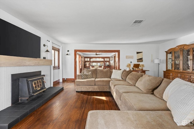 living area with dark wood-style floors, visible vents, and baseboards