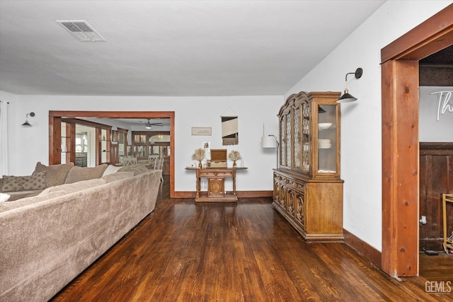 unfurnished living room with dark wood-style floors, baseboards, and visible vents