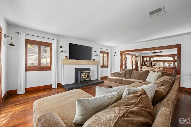 living area with wood finished floors, visible vents, and baseboards