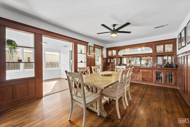 dining area with a ceiling fan, visible vents, and dark wood-type flooring