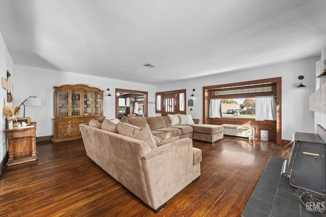 living area featuring a fireplace, visible vents, and dark wood-style flooring