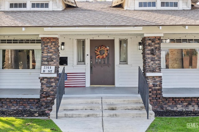 property entrance featuring a shingled roof