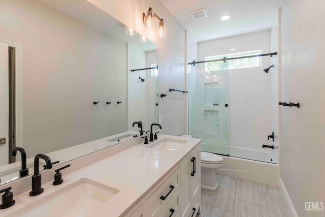 bathroom with toilet, a sink, and visible vents