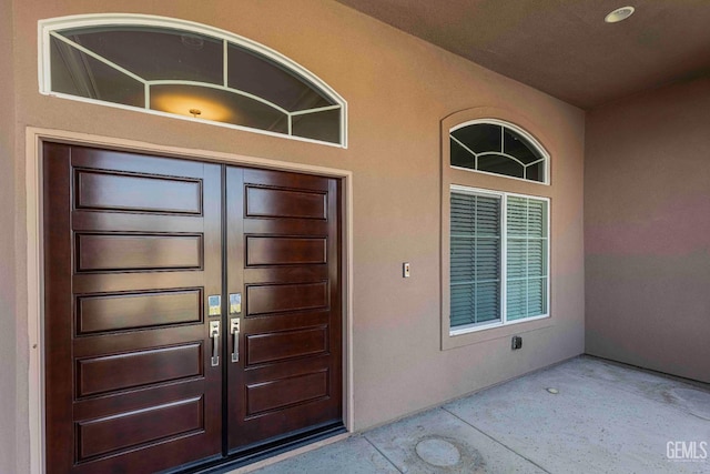entrance to property featuring french doors and stucco siding