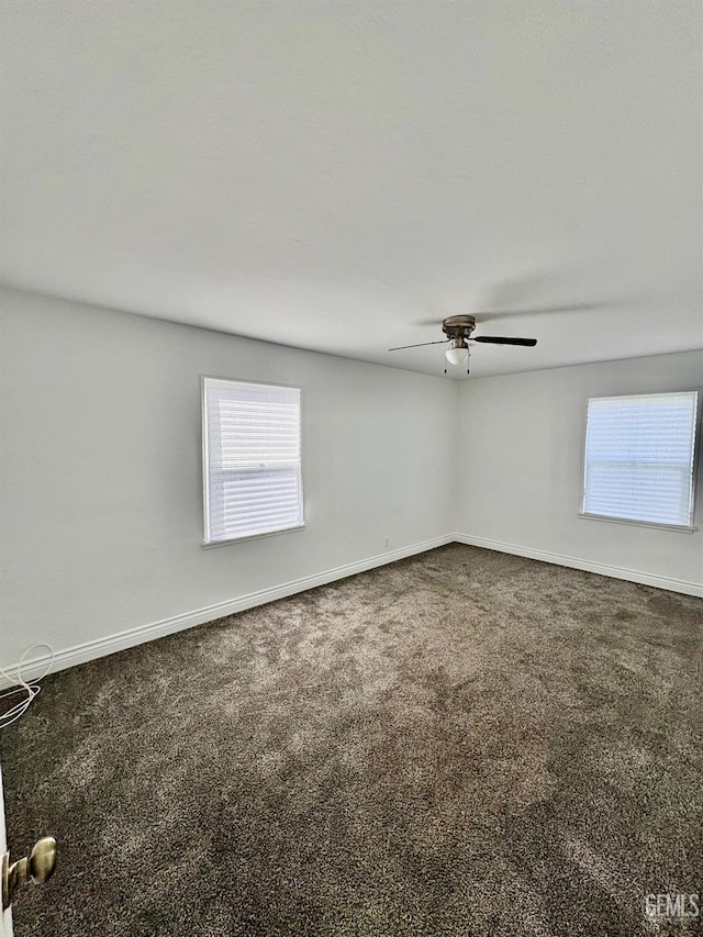 carpeted empty room with ceiling fan and baseboards