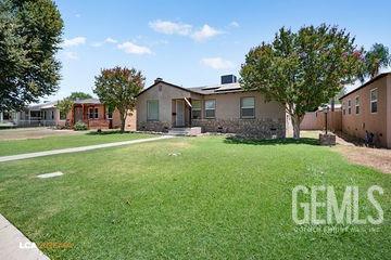 ranch-style house featuring solar panels and a front yard