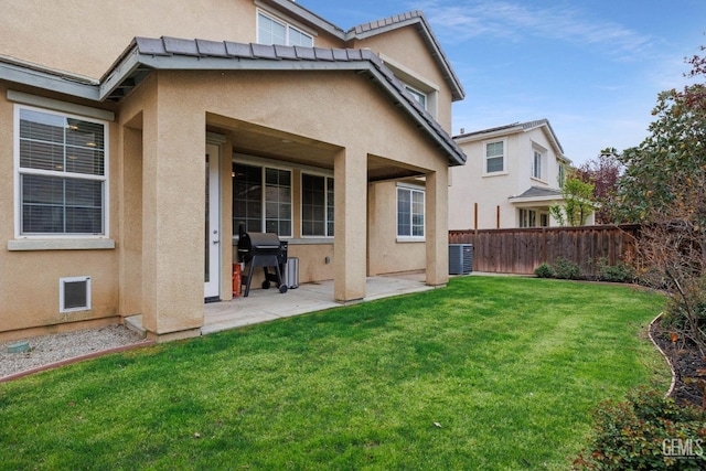 back of house with central AC unit, fence, a patio area, a yard, and stucco siding