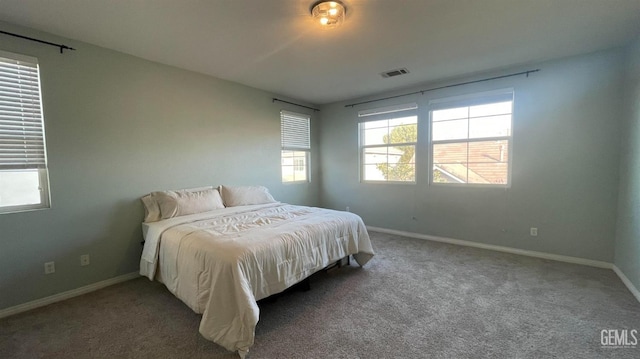 bedroom with carpet floors, visible vents, and baseboards