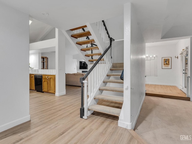 staircase with baseboards and wood finished floors