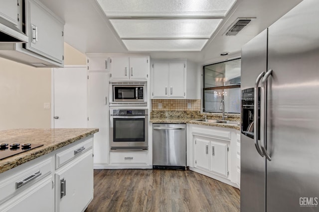 kitchen with a sink, visible vents, white cabinets, appliances with stainless steel finishes, and light stone countertops