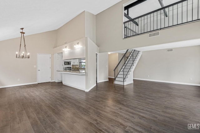 unfurnished living room with stairway, visible vents, and baseboards