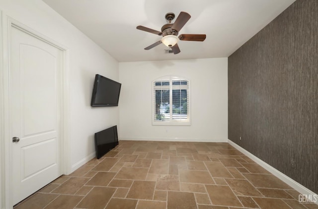 12603 Clay Creek Ct, Bakersfield, CA 93312 - unfurnished room with stone tile floors, an accent wall, and ceiling fan