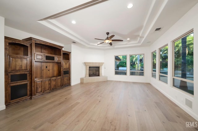 12603 Clay Creek Ct, Bakersfield, CA 93312 - unfurnished living room with a tray ceiling, a fireplace, light wood finished floors, a ceiling fan, and recessed lighting