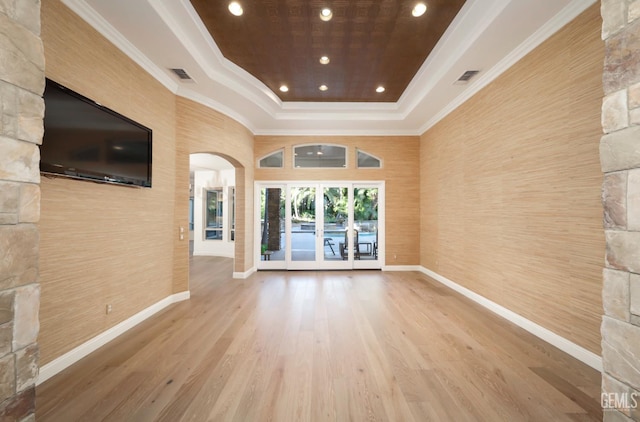 12603 Clay Creek Ct, Bakersfield, CA 93312 - unfurnished living room with a tray ceiling, wood finished floors, ornamental molding, arched walkways, and french doors